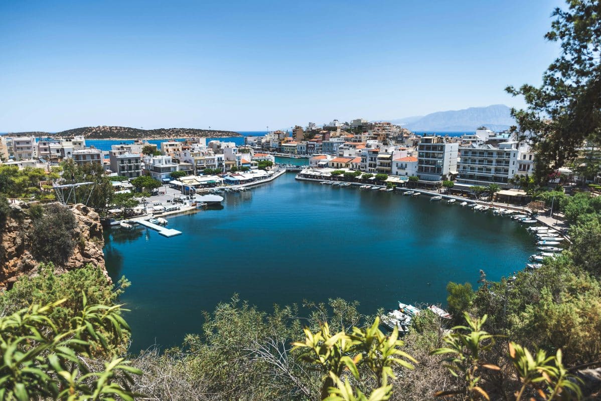 Affordable Greek island town of Agios Nikolaos in Crete with harbor views and waterfront buildings