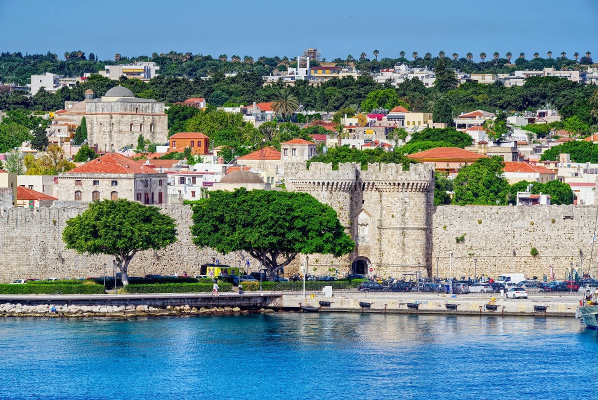 View of Rhodes Old Town walls and harbor from the water in the Greek islands