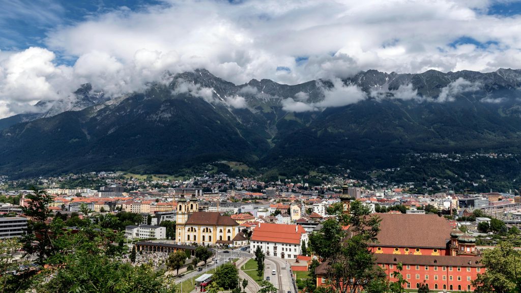 Innsbruck Austria city skyline with colorful buildings and the Alps mountains in the background