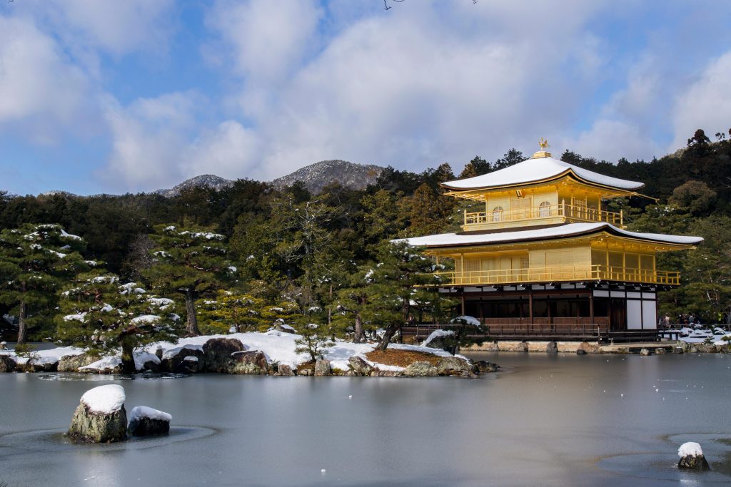 Kinkaku-ji Golden Pavilion in Kyoto Japan surrounded by snow and reflected in the pond