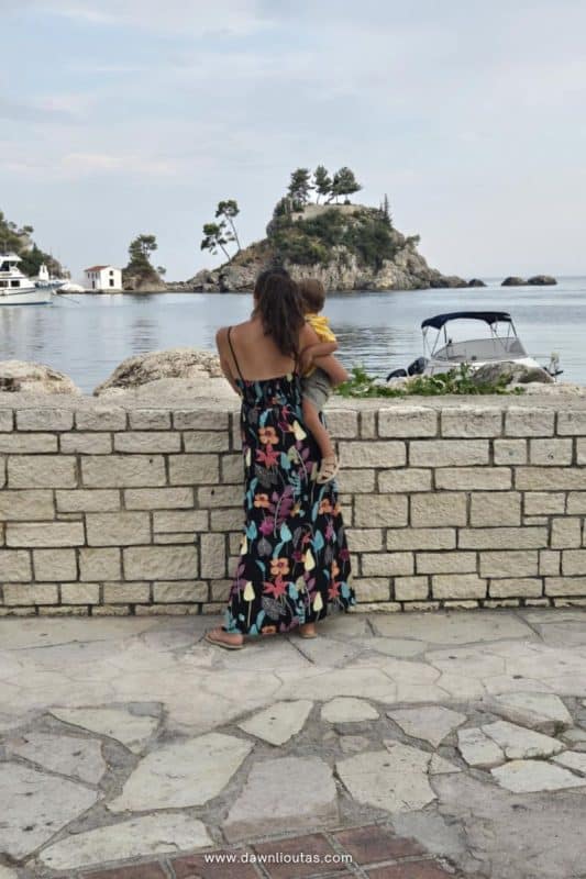 Woman walking along the waterfront in Parga Greece with coastal island view