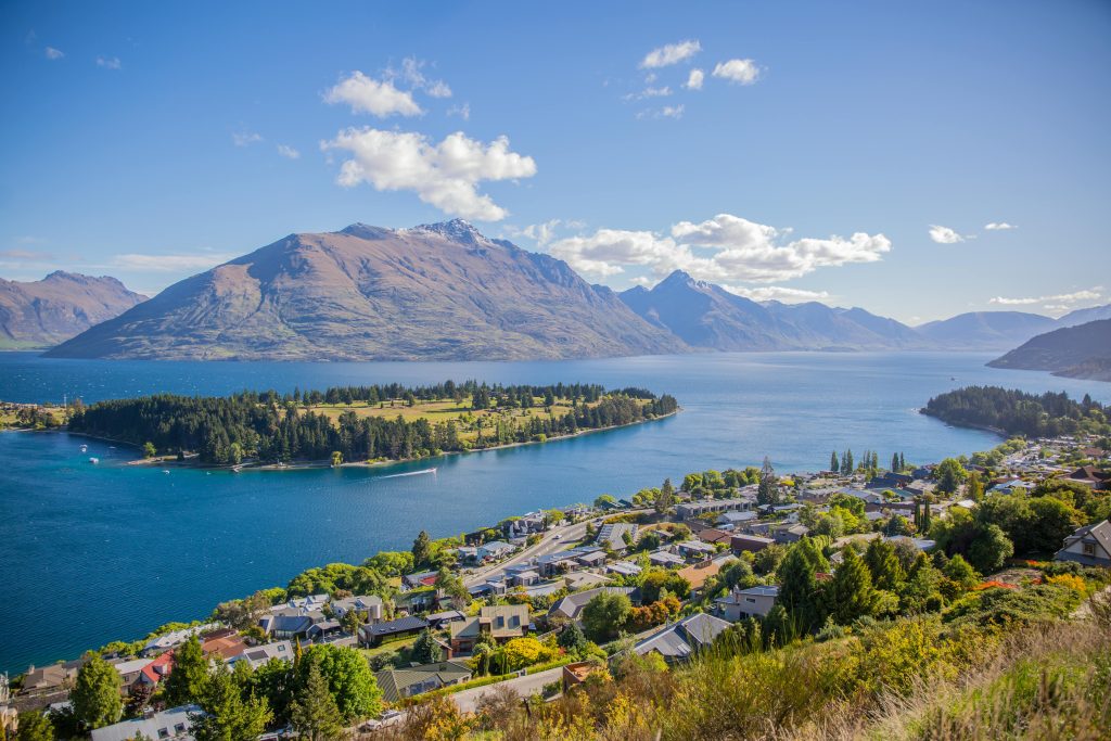 Aerial view of Queenstown New Zealand with Lake Wakatipu and surrounding mountains on a sunny day