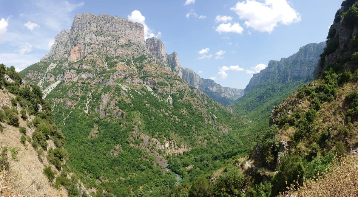 Panoramic view of Vikos Gorge in Zagori, Epirus Greece with dramatic cliffs and the Voidomatis River below