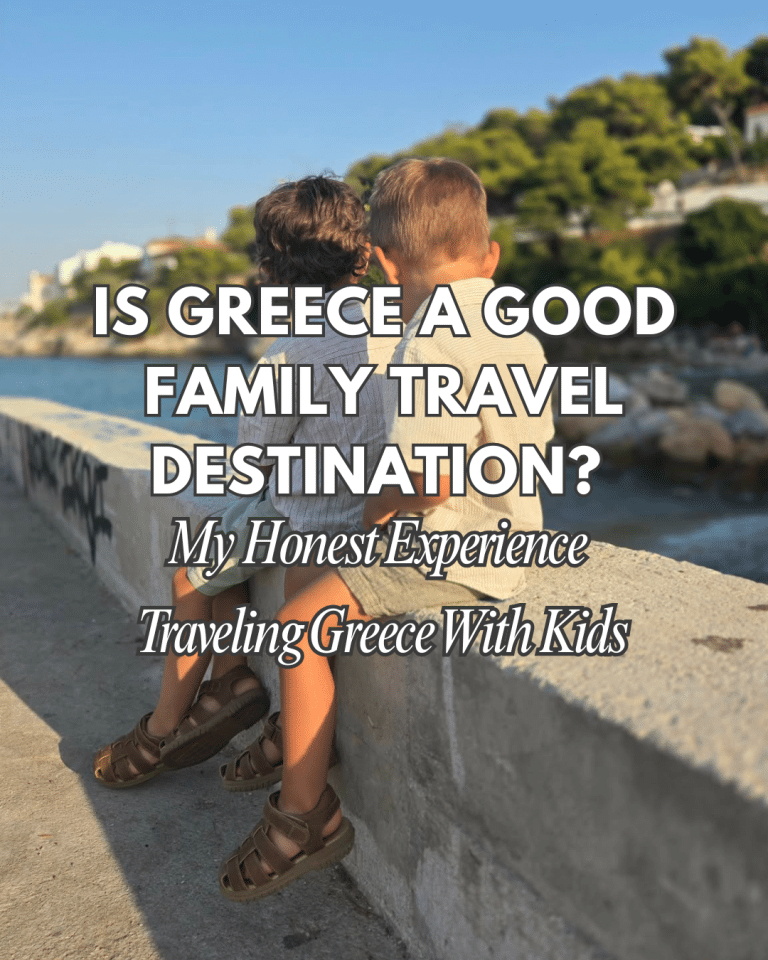 Two young children sit side by side on a stone wall overlooking the sea in Greece, enjoying a calm coastal view during a family trip.