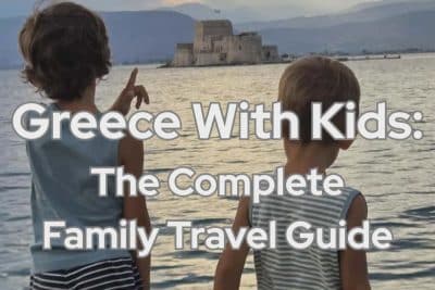 Two children looking toward Bourtzi Castle in Nafplio, Greece at sunset during a family trip.