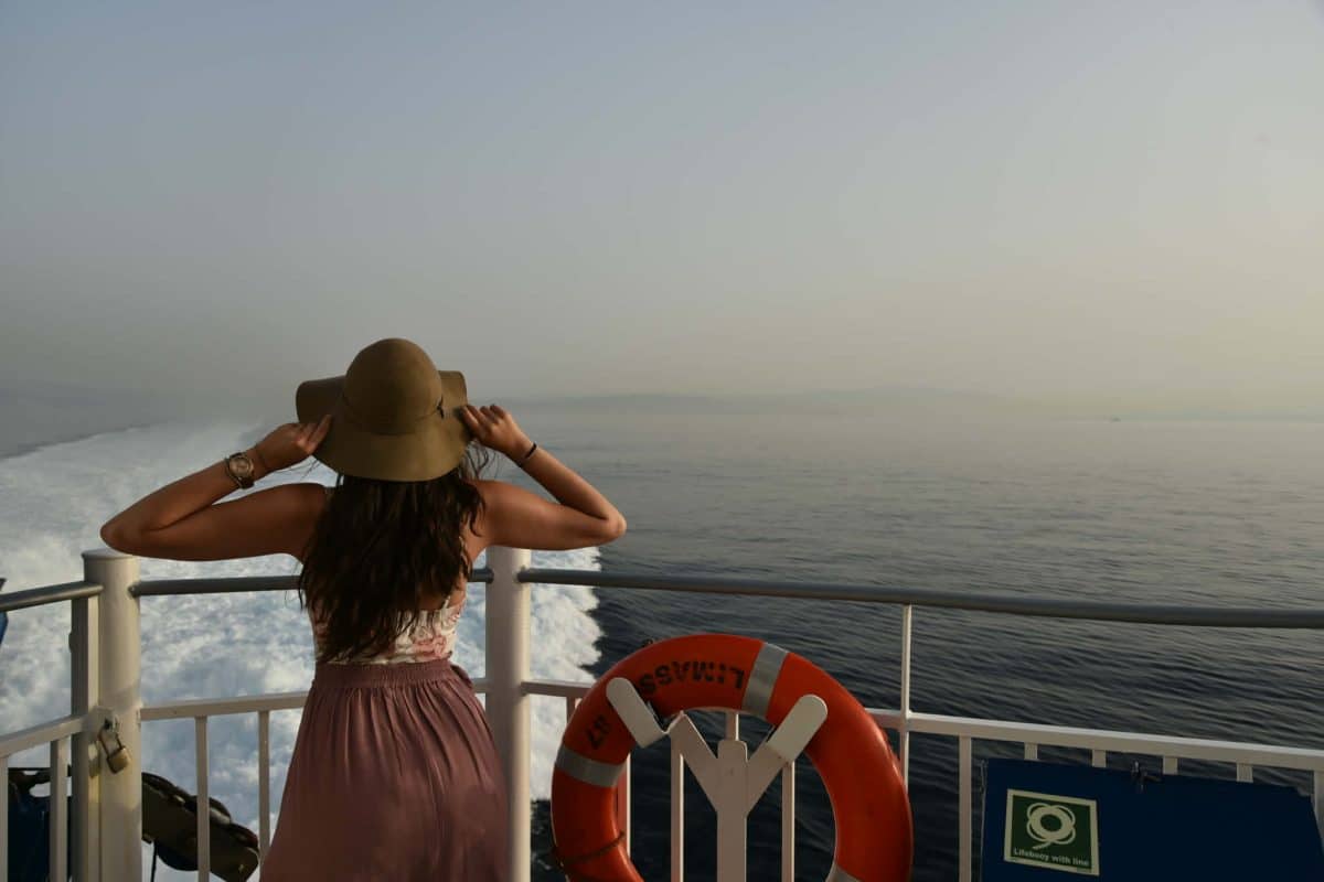 Traveler looking out at the Aegean Sea from a ferry while island hopping in Greece