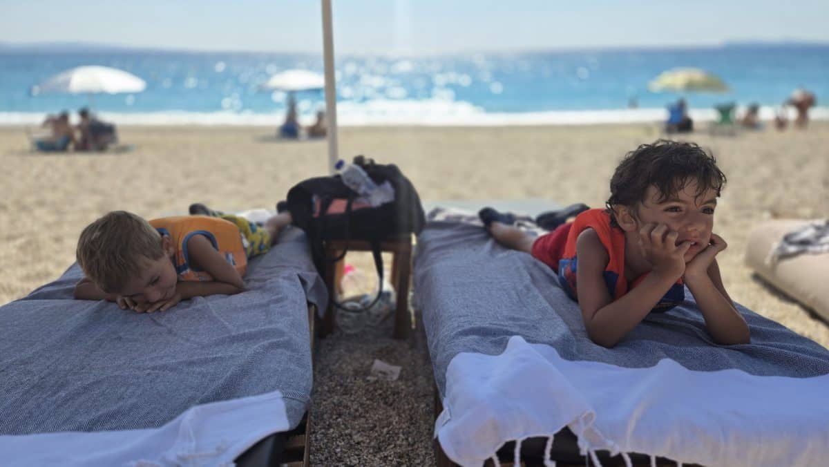 Kids relaxing on beach loungers in Greece during a family vacation