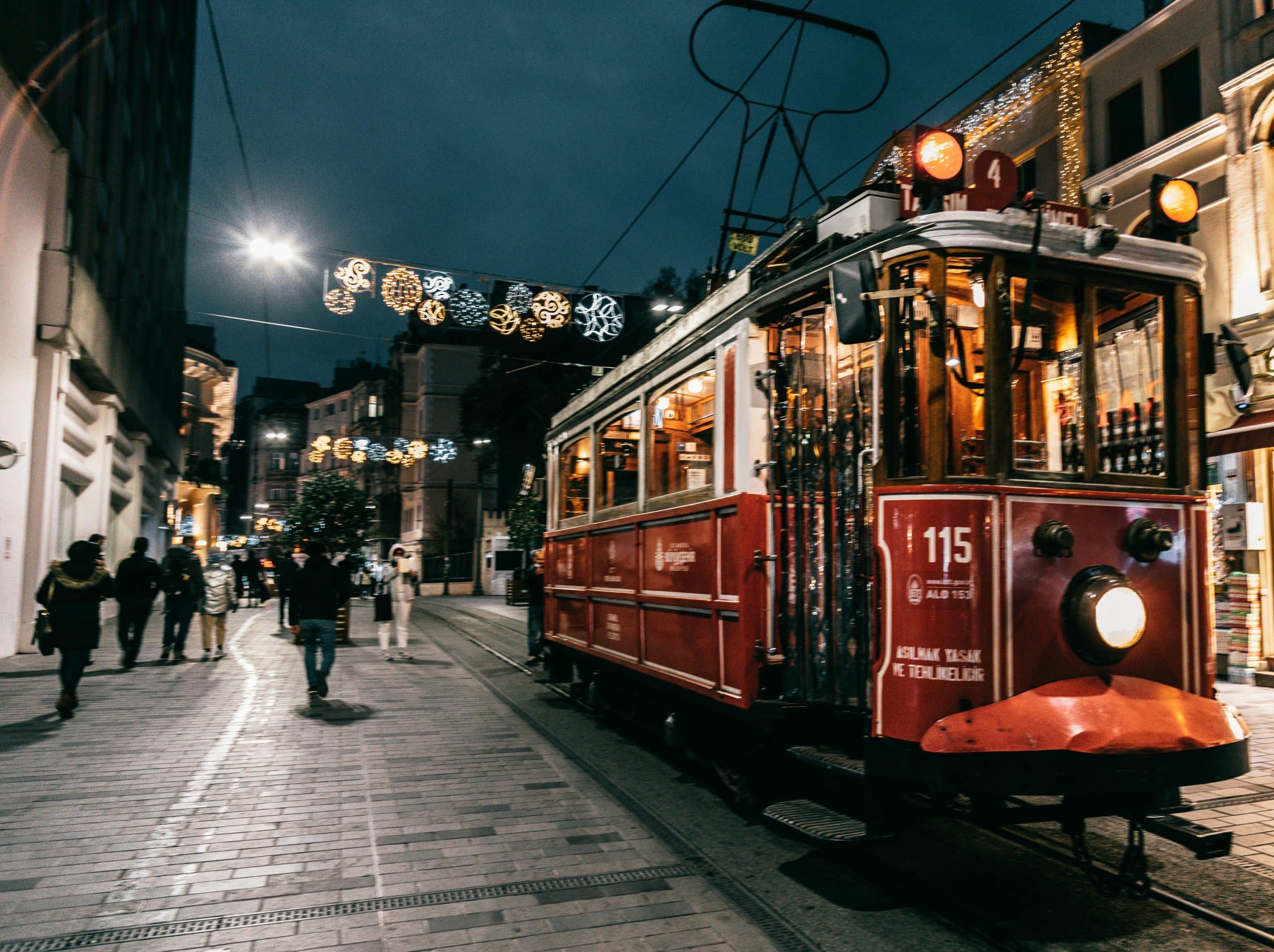 Historic red tram on Istiklal Street in Taksim Istanbul with people boarding