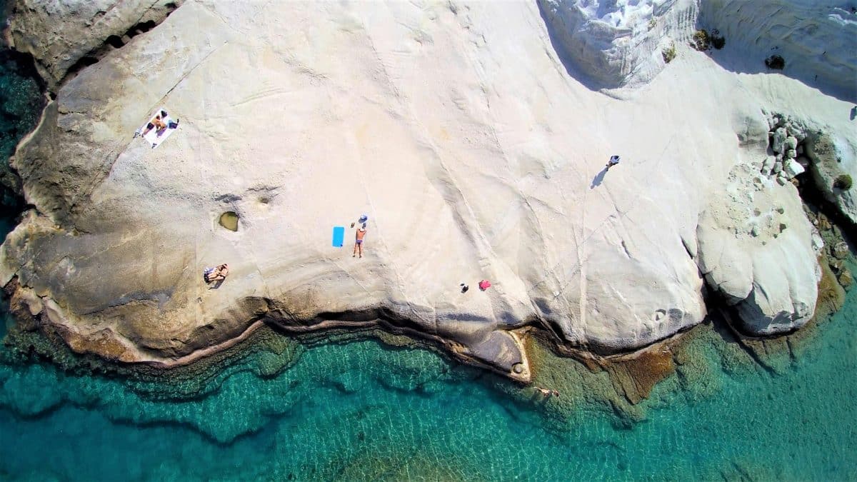Aerial view of Sarakiniko Beach in Milos with white volcanic rock formations and turquoise water.