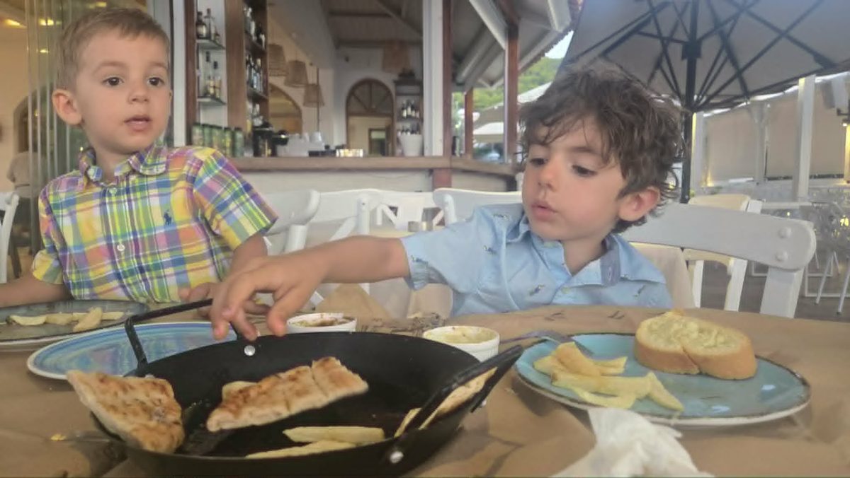 Kids eating Greek food at a family-friendly restaurant in Skala Agkistri Greece