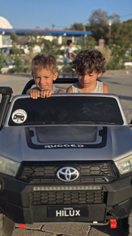 Kids driving ride-on toy car in Skala Agkistri Greece family travel