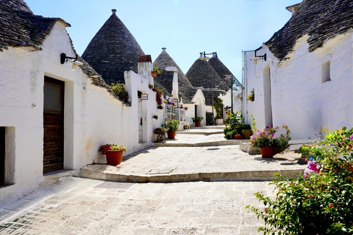 Traditional trulli houses in Alberobello Puglia Italy with white walls and cone shaped roofs