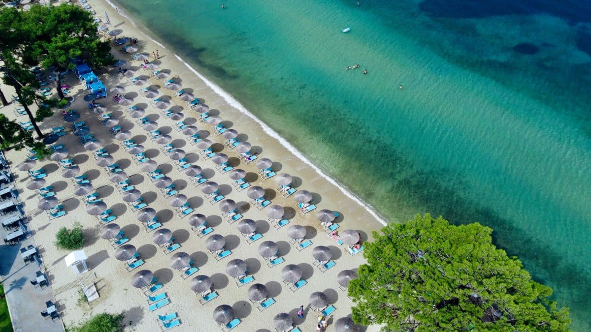 Thassos beach with sunbeds and umbrellas and clear turquoise water in Greece