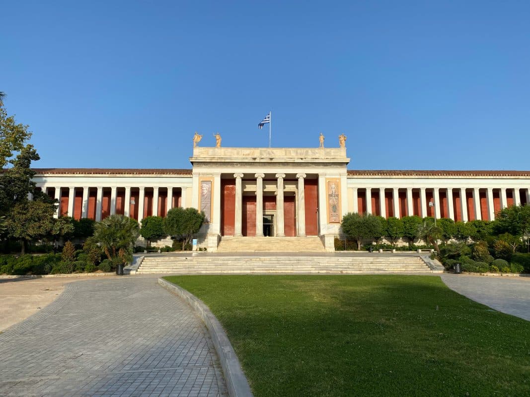The National Archaeological Museum building in Athens, Greece with gardens and a Greek flag