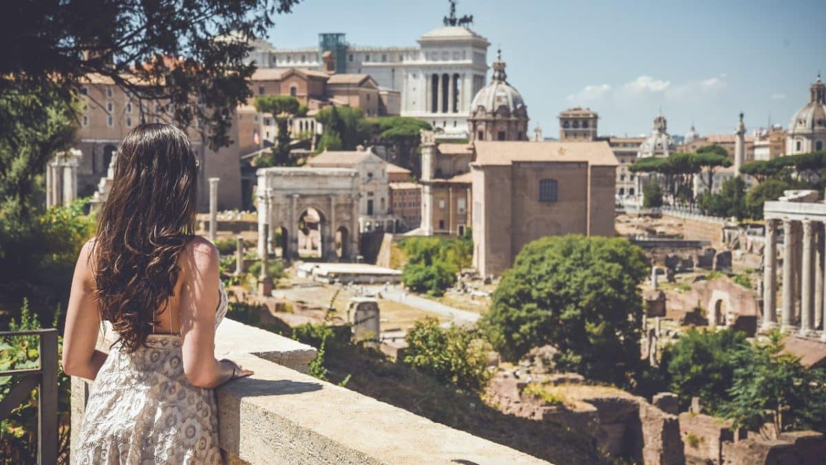 Woman overlooking the Roman Forum and historic ruins in Rome, Italy