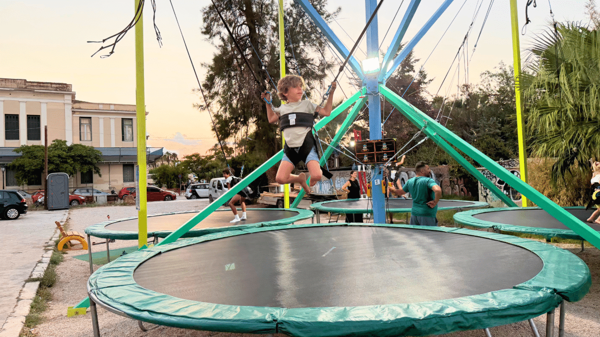 Child enjoying a bungee trampoline at OSE Luna Park in Nafplio, Greece