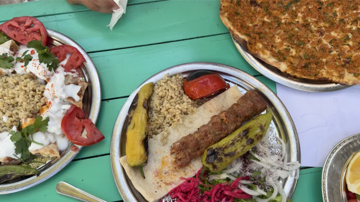 Traditional Turkish meal in Bodrum featuring grilled kebab, bulgur wheat, flatbread, grilled vegetables and yogurt.
