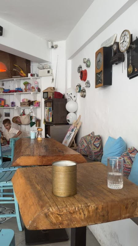Interior of Frenk Cafe in Bodrum, Turkey, featuring rustic wooden tables, colourful décor and a children’s play area.
