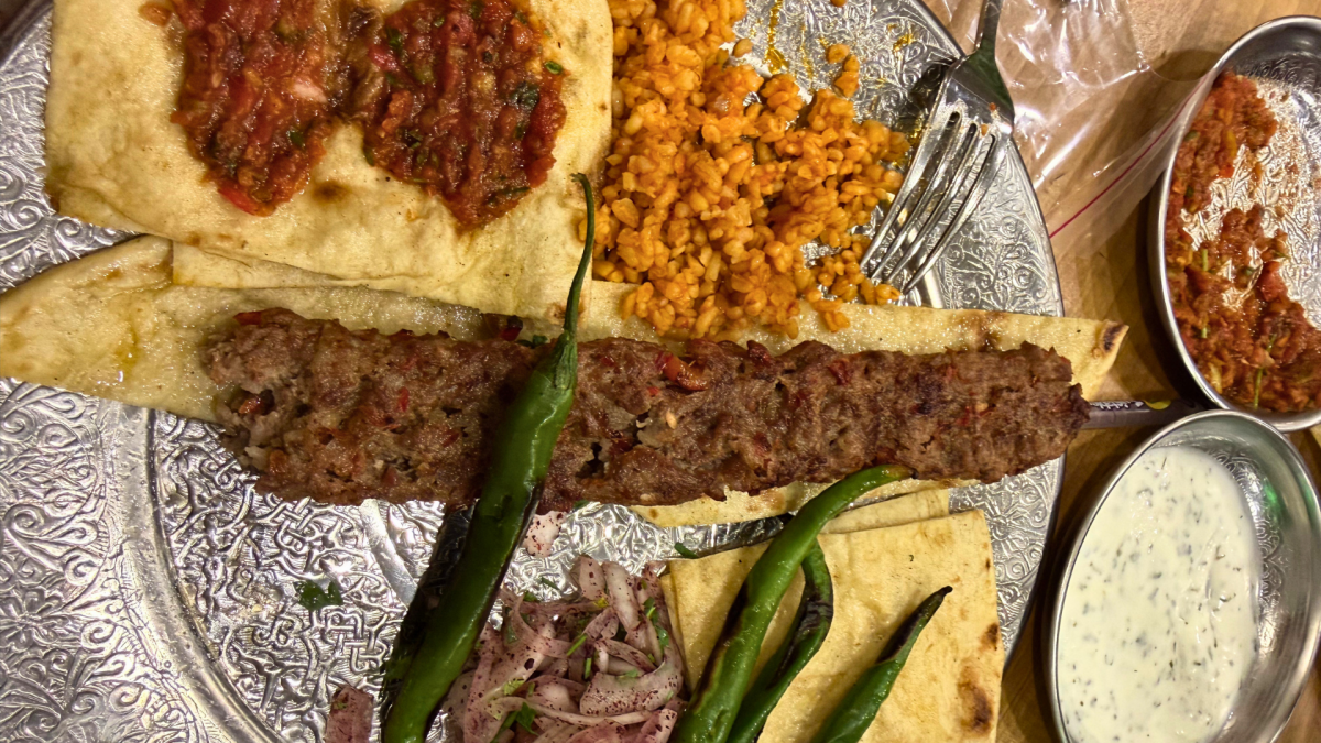 Traditional Turkish grilled meat kebab served with flatbread, bulgur wheat, green peppers, and yogurt sauce at Ye Gari restaurant in Bodrum, Turkey.