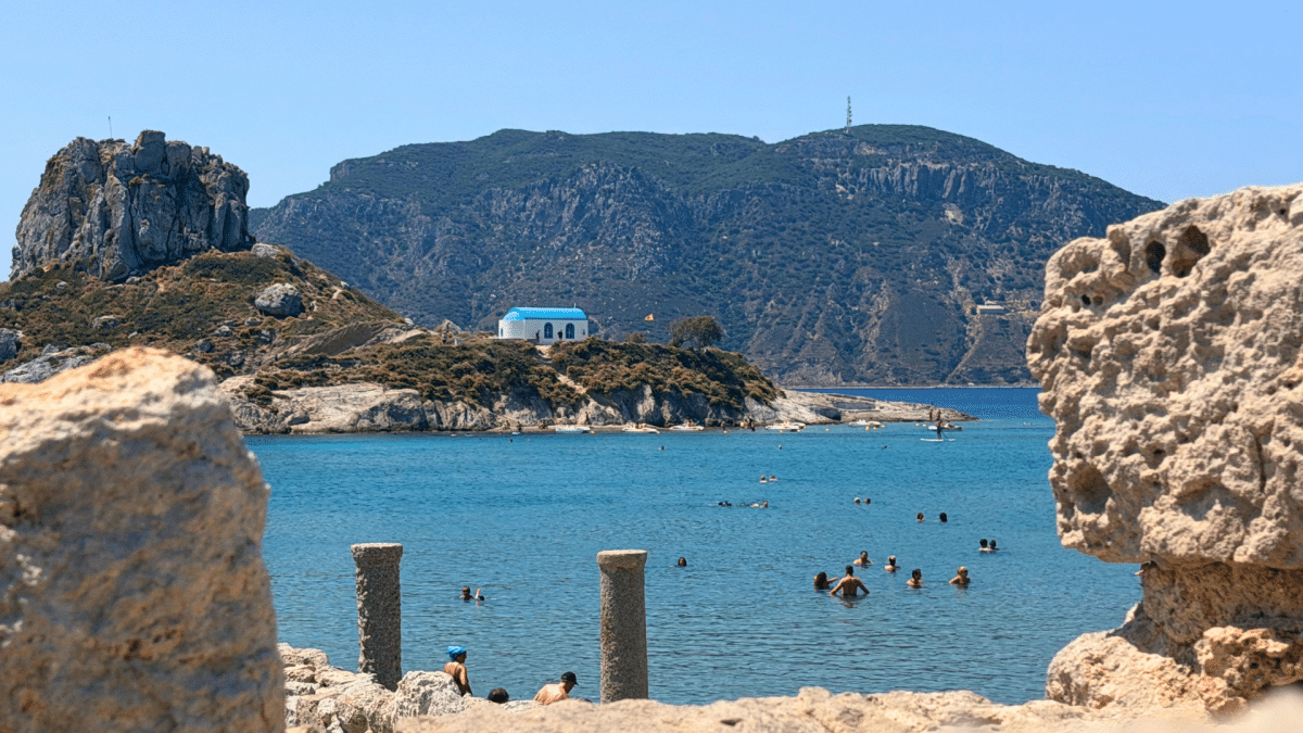 Agios Stefanos Beach in Kos, Greece, with ancient ruins, turquoise water and a small Greek chapel
