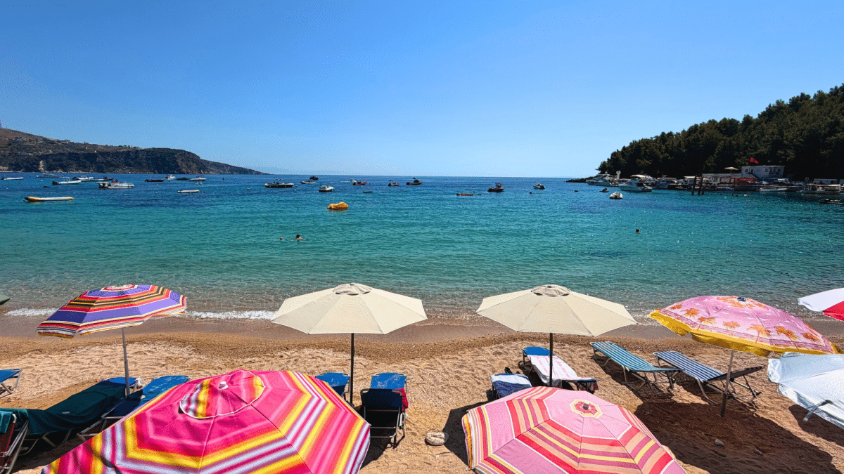 Colourful beach umbrellas along the turquoise water at Himarë Beach, Albania
