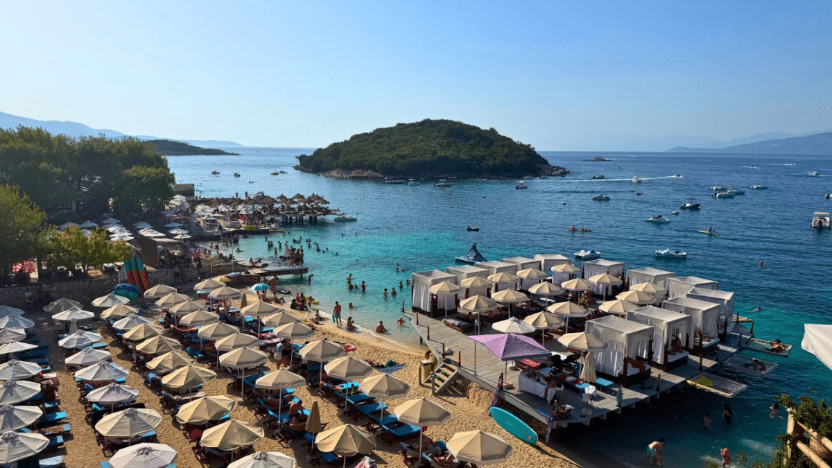 Ksamil Beach in Albania with turquoise water, beach umbrellas and waterfront beach clubs